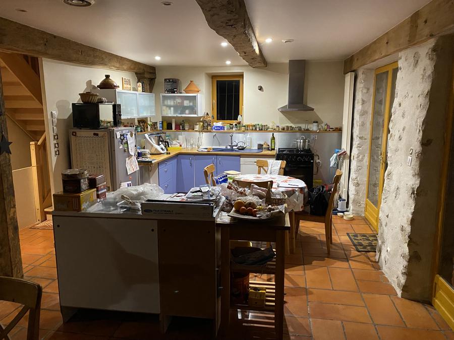 Avant rénovation : cuisine rustique avec tommettes, poutres et cheminée en pierre à Aix-les-Bains