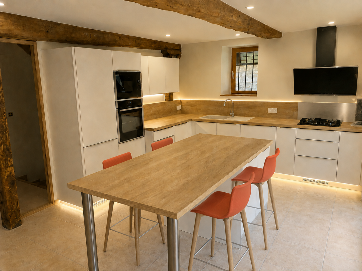 Après rénovation : cuisine design blanche et chêne massif avec îlot central sous poutres apparentes, réalisée par un cuisiniste à Aix-les-Bains